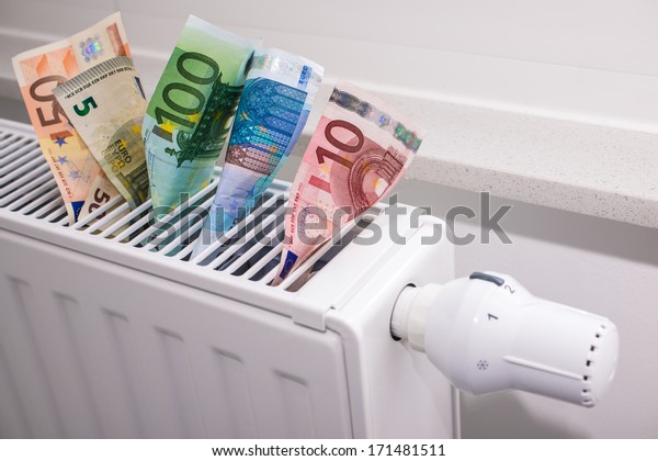 heating thermostat with money, expensive heating\
costs concept