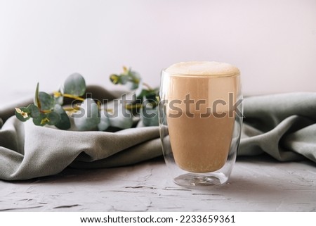Heat-resistant double-walled glass cup filled with latte or cappuccino