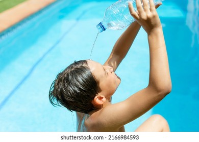 Heatstroke.heatwave. Cool off in the summer heat wave in the pool. young man splashing a bottle of water on his face. Concept of high temperatures in summer.heat stroke and heat wave