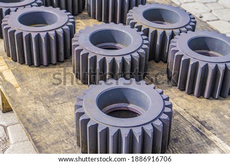 Heat-treated gears on a wooden rack, cool down after quenching in an oven. Gear cutting production concept