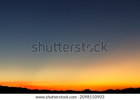 Heaven at early morning with copy space. Sunset, sunrise backdrop.Predawn clear sky with orange horizon and blue atmosphere. Smooth orange blue gradient of dawn sky. 