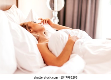 Heavenly Bed. Attractive Woman Relaxing In A Hotel. Copy Space In Upper Right Part