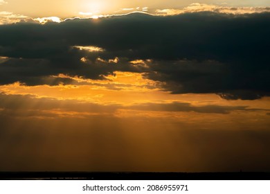 The heavenly light of the sun.Dramatic evening sky with clouds and rays of the sun.Sunlight at evening sunset or morning sunrise.Panoramic view of clouds in motion.Golden rays of the sun and clouds
