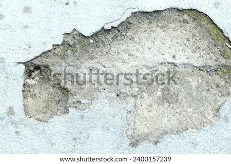 Heavily damaged old facade wall . Paint peeling off showing the coating of the wall. 