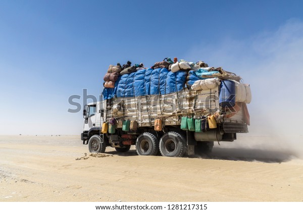 Heavily loaded truck transporting\
goods and people in the Sahara desert, November 7, 2017,\
Chad