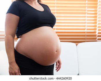 A heavily pregnant woman and large belly.