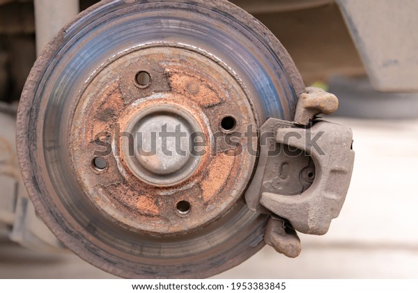 Heavily worn brake disc.\
Car brake disc after removing the wheel. A rusty disk that needs to\
be replaced.