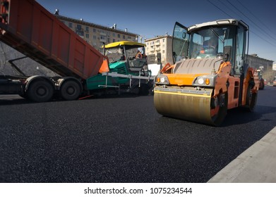 Heavy Asphalt Paver Red Truck And Road Vibrating Roller Seal Ready For Repair Roads In A Modern City