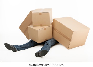 Too heavy boxes. Deliveryman lying covered with a stack of cardboard boxes while isolated on white