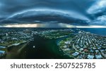 Heavy clouds of a storm front over the Loxahatchee River and the city of Jupiter in early August. Rain is visible, which pours out of the clouds on the city