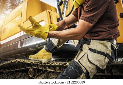 Heavy Construction Equipment Caucasian Operator Wearing Safety Gloves. Bulldozer Or Crawler Operator At Work. Industrial Theme.