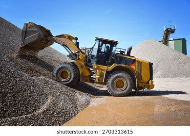 heavy construction machine in open-cast mining - wheel loader transports gravel in a gravel plant 