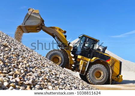 heavy construction machine in open-cast mining - wheel loader transports gravel in a gravel plant 