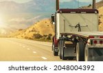 Heavy Duty Freight Theme. Semi Truck with Flatbed Trailer on a Scenic Utah Interstate 70 Highway. American Transportation Industry.