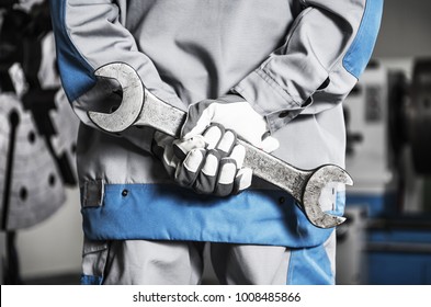 Heavy Duty Machinery Mechanic On A Duty With Huge Metal Wrench In Hands.