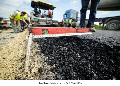 Heavy duty road building. Hot Asphalt being laid and measured for a quality check as a part of a on site control test.