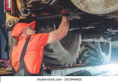 Heavy Duty Tractor Under Maintenance. Professional Service Worker. Caucasian Industrial Mechanic in His 30s.