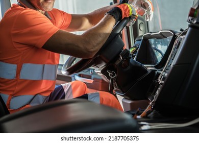 Heavy Duty Transportation Theme. Caucasian Semi Truck Driver Inside Vehicle Cabin Keeping His Hands On A Steering Wheel.