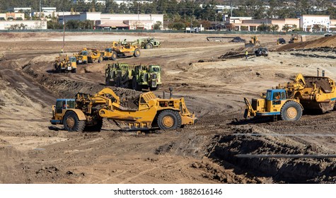 Heavy Earthmoving Equipment Including Scapers And Motor Graders Involved In Grading Operations At A Construction Site