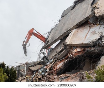 Heavy Equipment Being Used To Tear Tearing Down Building Construction. Excavator Working On A Demolition Site