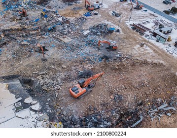 Heavy Equipment Being Used To Tear Tearing Down Building Construction. Excavator Working On A Demolition Site. Drone View 