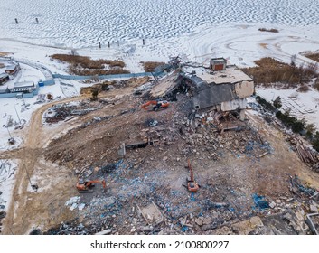 Heavy Equipment Being Used To Tear Tearing Down Building Construction. Excavator Working On A Demolition Site. Drone View 