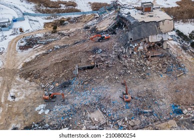 Heavy Equipment Being Used To Tear Tearing Down Building Construction. Excavator Working On A Demolition Site. Drone View 