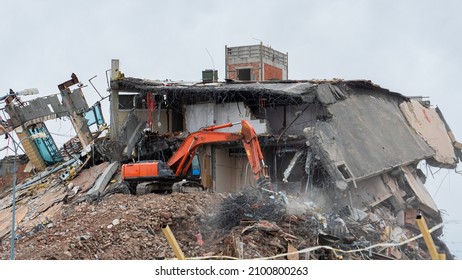 Heavy Equipment Being Used To Tear Tearing Down Building Construction. Excavator Working On A Demolition Site