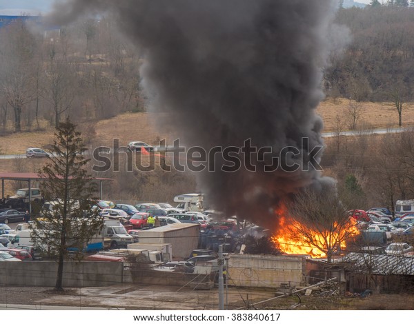 Heavy fire accident at big car service with\
blazing orange flame and high black\
smoke