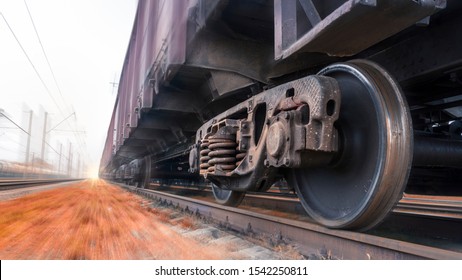 A Heavy Freight Train Travels Quickly By Rail. Sensation Of Movement By Blurring The Background. Fast Cargo Delivery By Train. Side Bottom View Of The Train