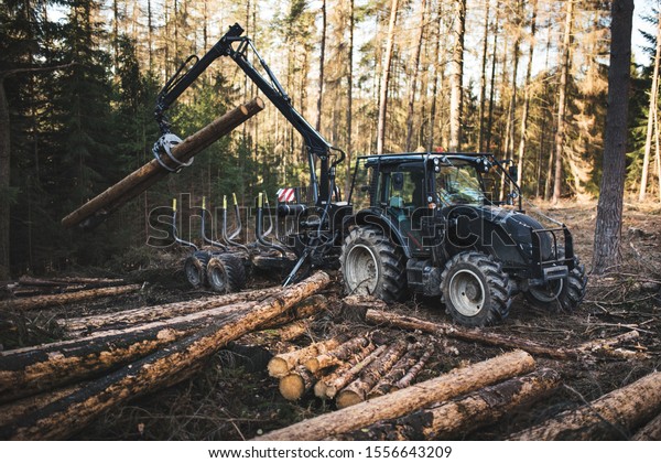 \
Heavy\
industrial machinery working in the forest. Harvester in a spruce\
forest working with logs. Heavy machinery.\
