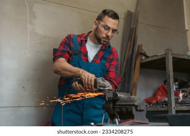 Heavy Industry Engineering Factory Interior with Industrial Worker Using Angle Grinder and Cutting a Metal. Contractor in Safety Uniform and protective glasses cutting metal. - Powered by Shutterstock