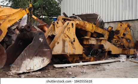 Heavy machinery scrap yard. Parts of excavators and heavy excavation vehicles that have reached the end of their useful life. Buckets, gear sets, tracks, shock absorber springs and flywheel gears. - Powered by Shutterstock