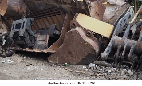 Heavy machinery scrap yard. Parts of excavators and heavy excavation vehicles that have reached the end of their useful life. Buckets, gear sets, tracks, shock absorber springs and flywheel gears. - Powered by Shutterstock