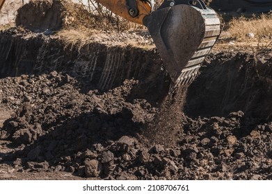 Heavy Machinery At Work, Backhoe Removing Dirt From A Material Bank.