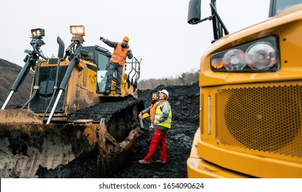 Heavy Machinery And Workers In Pit Of Quarry Shouting At Each Other Because The Noise Is Unbearable