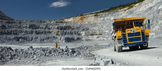 Heavy Mining Dump Truck On The Background Of A Stone Quarry Close-up, Panorama.