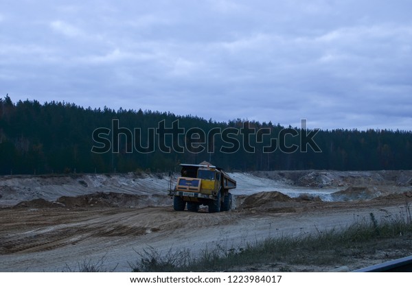 Heavy\
mining truck driving through the iron ore\
opencast
