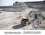 Heavy mining truck and excavator, close-up, against the background of the panorama of a limestone quarry.