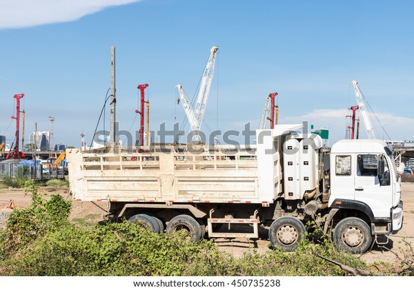 Heavy modern truck is parking near the construction
site in the city.