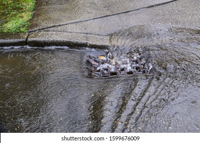 Heavy Rain Caused Flooding In Street, Water Swirling Around Storm Drain
