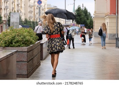 Heavy Rain In A City, Girl With Umbrella Walk On A Street On People Background. Rainy Weather In Moscow, Summer Storm