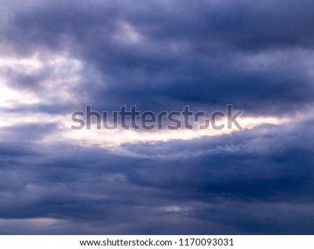 Heavy rain clouds and bright rift in the sky
