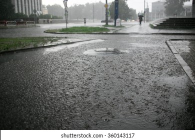 Heavy Rain Drops Falling On City Street During Downpour