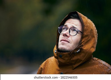 Heavy Rain During Autumn Day. Portrait Of Young Man In Waterproof Jacket.    