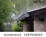 Heavy rain falling on the roof and metal gutter of brick house in summer season