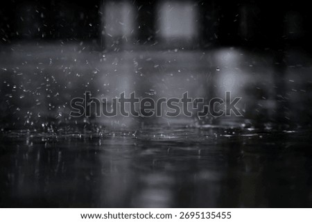 heavy raining make many small splash crown from water droplets drop down to the concrete floor in blue tone color scene 