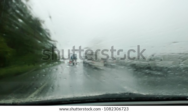 Heavy rains summer\
months of April due to summer storms. Abstract blur of rain drops\
falling on the\
windscreen.