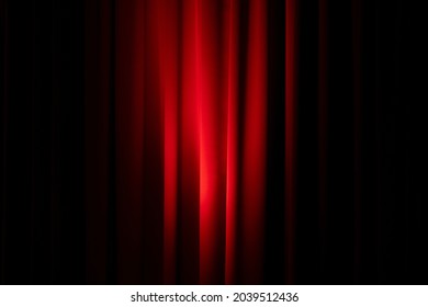 Heavy red curtain with spot light on the middle of it
