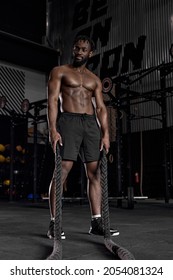 Heavy Ropes Training. African American Muscular Man In Workout Gear Going To Exercising With Battle Ropes At The Gym Cross Training Motivation Challenge Improvement Achievement Strength